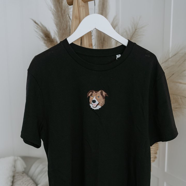 A Black Embroidered Pet Portrait Organic T-shirt hanging on the wardrobe with border colie pet portrait on the T-shirt